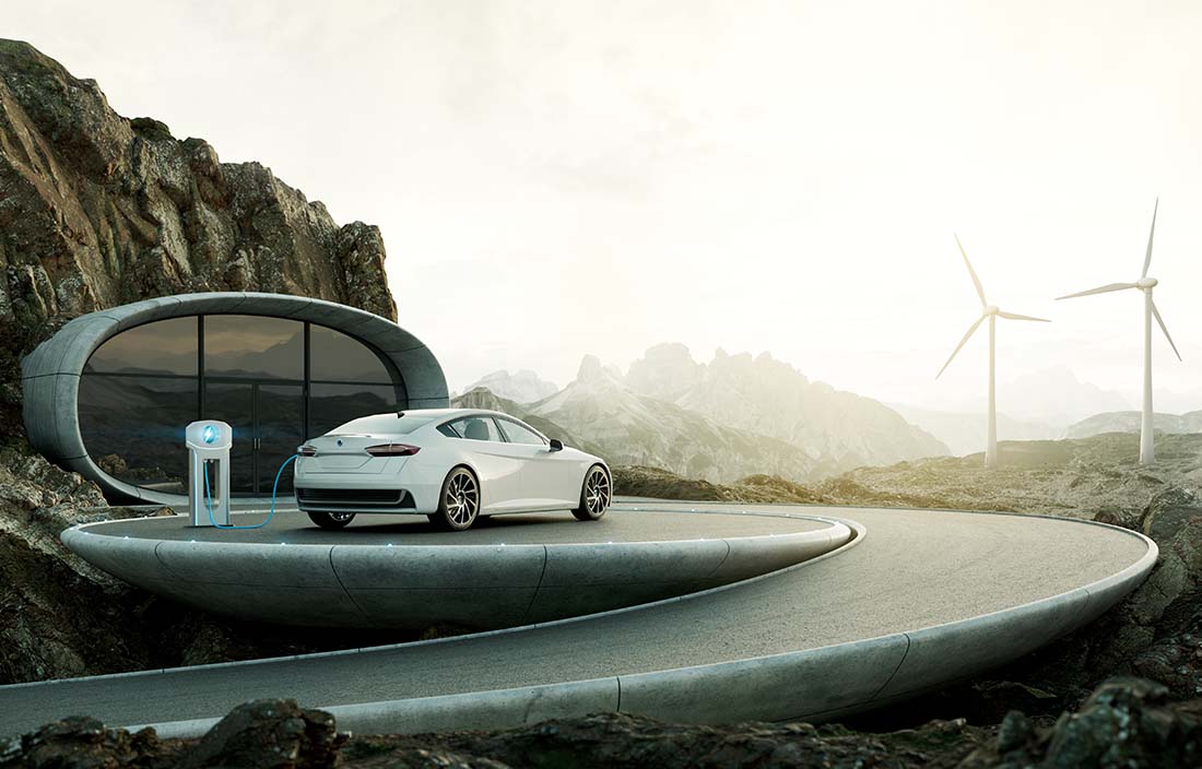 Electrical vehicle charge by the side of a cliff, with windmills in the background.