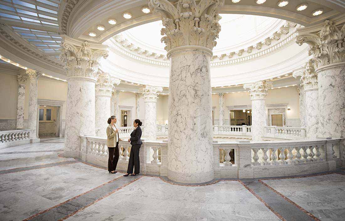Two business professionals standing by white pillars discussing international tax updates.